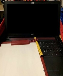ハンモックでノートパソコンとクリップボードにコピー用紙を挟んで作業をしているところ